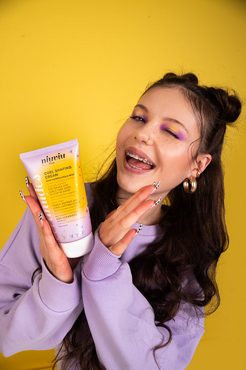 niuviu Bounce Curl Shaping Cream w liliowo-żółtym opakowaniu, dziewczyna z fioletowym cieniem