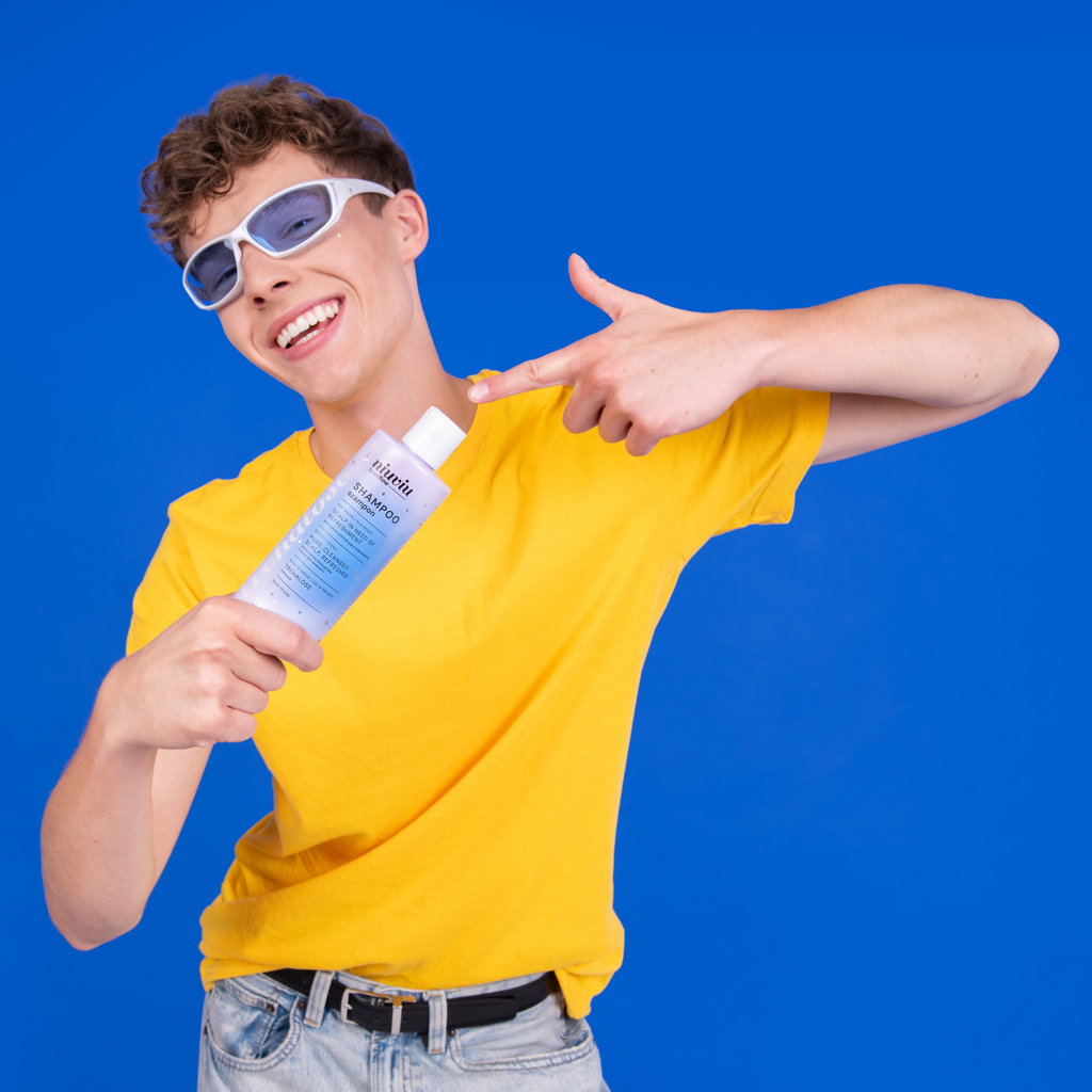 niuviu Pure szampon w niebieskim opakowaniu, trzymany przez osobę w żółtej koszulce